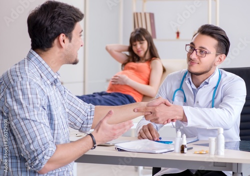 Pregnant woman with her husband visiting the doctor in clinic