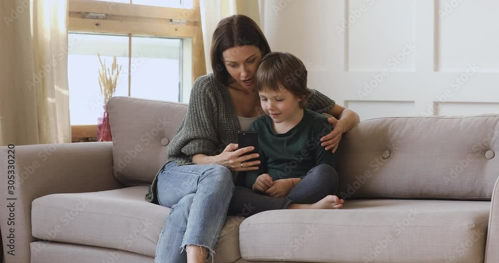 Happy mum teaching kid son learning using smartphone apps Happy mum teaching kid son learning using smartphone apps