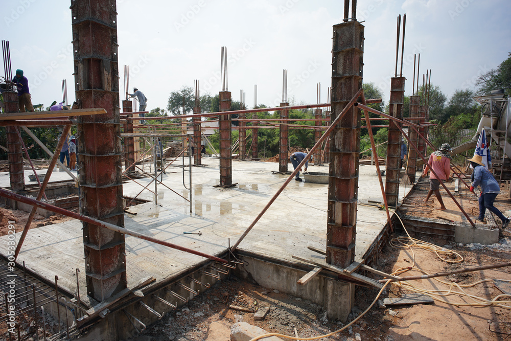 Ratchaburi, Thailand:March 1, 2018 - Group of worker build the foundation of house by pouring the mixed cement into the wooden model at the construction site Ratchaburi, Thailand:March 1, 2018 - Group of worker build the foundation of house by pouring the mixed cement into the wooden model at the construction site