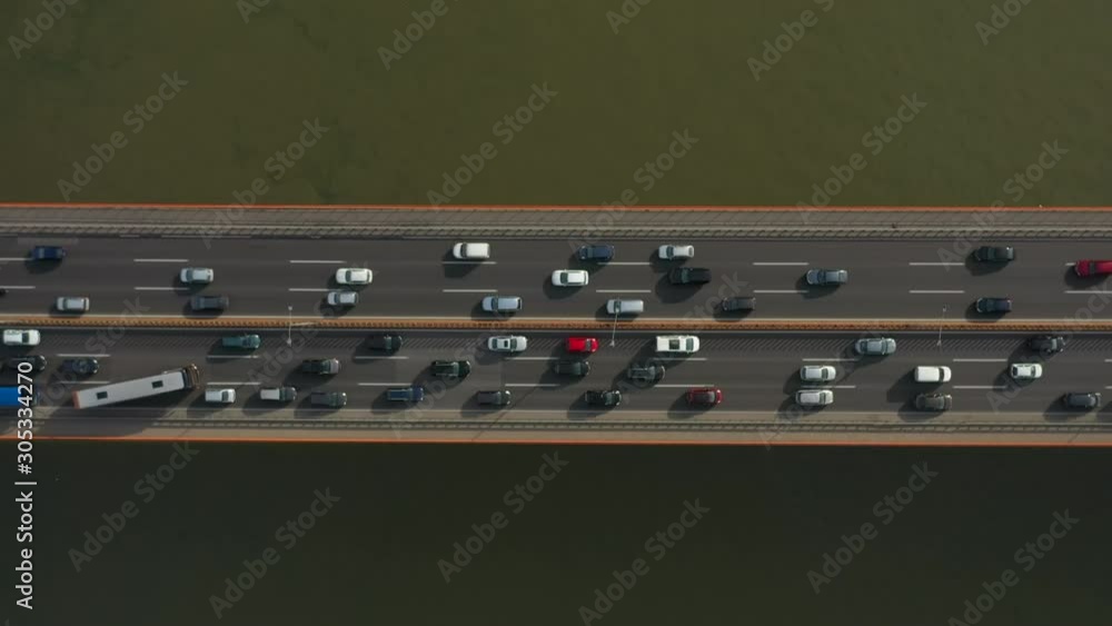 Zoom In Cinematic Traffic Rush video of cars vehicles passing on the river water bridge, Birds eye perspective aerial shoot. Zoom In Cinematic Traffic Rush video of cars vehicles passing on the river water bridge, Birds eye perspective aerial shoot.