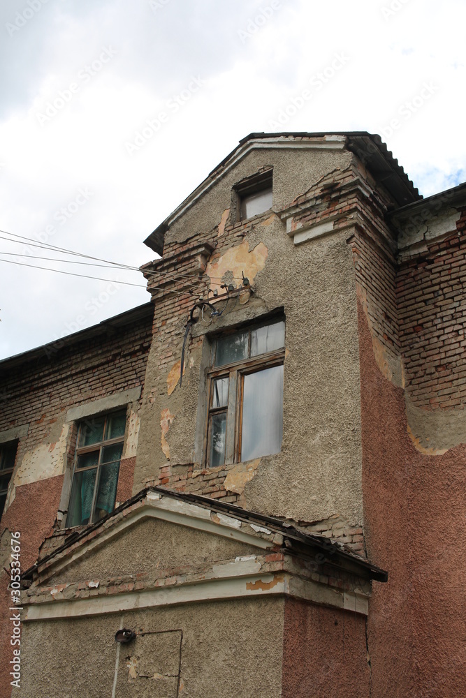 the old ruined building with dirty broken Windows on the figured facade is a historical monument