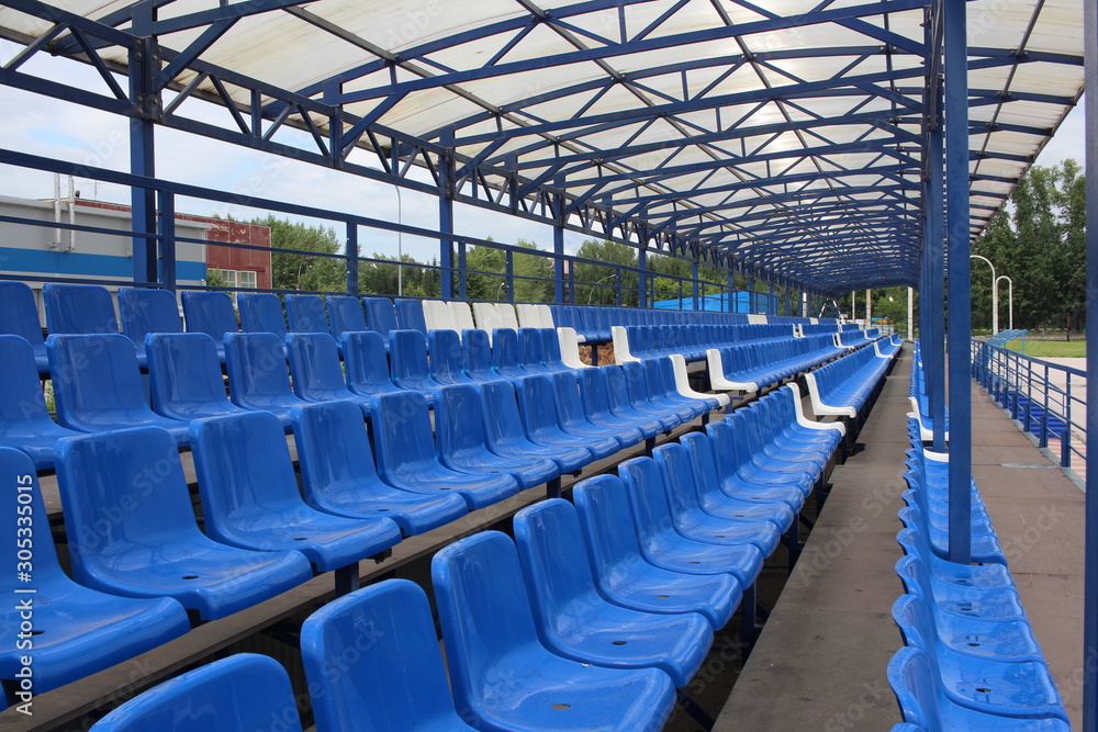 Naklejka premium long rows of blue empty seats in the stadium for spectators