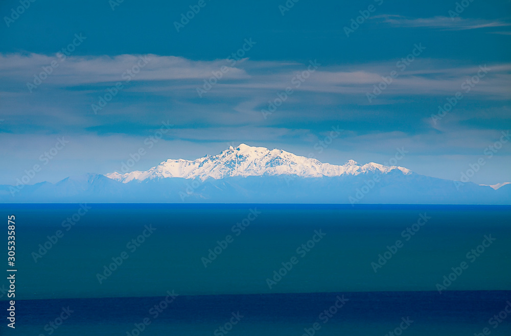 Snow caped mountain peaks in the Southern Alps viewed from the tip of the North Island  at Ngawi