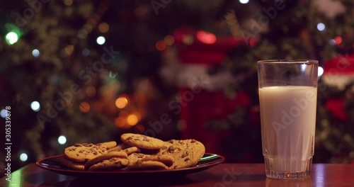 Santa eating cookies and drinking milk, then stuffing his face in front of christmas tree - shot on RED