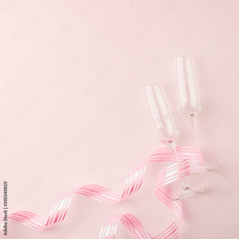 Valentines day greeting card. Empty Wine glasses for wine and ribbon on a soft light pink background. Flat lay, top view, copy space, minimal february romance concept Valentines day greeting card. Empty Wine glasses for wine and ribbon on a soft light pink background. Flat lay, top view, copy space, minimal february romance concept