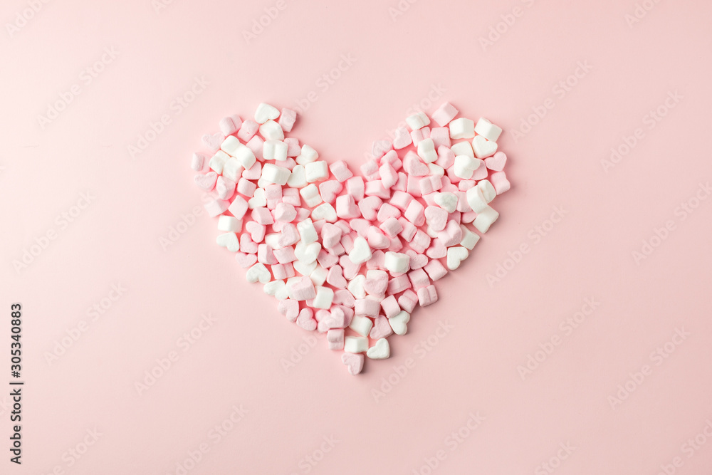 Pink marshmallow in heart shape stacked on pink table with copy space. Sweet candy for love theme on Valentine concept in vintage style. Pastel color dessert