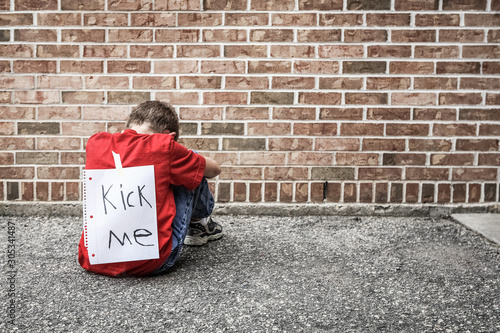 Fényképezés Sad boy with a kick me sign taped to his back, bullying concept
