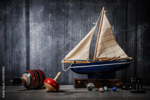 Billede på lærred Vintage toy still life with boat, tops, marbles and dominos