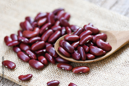 Red bean in wooden spoon on sack background - Grains red kidney beans