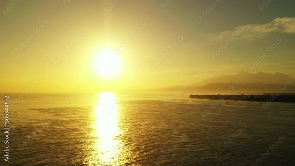 The Beautiful Setting Sun Over The Calm Waters Of The Bahamas With Mountains And A Small Island In The Background - Aerial Shot The Beautiful Setting Sun Over The Calm Waters Of The Bahamas With Mountains And A Small Island In The Background - Aerial Shot