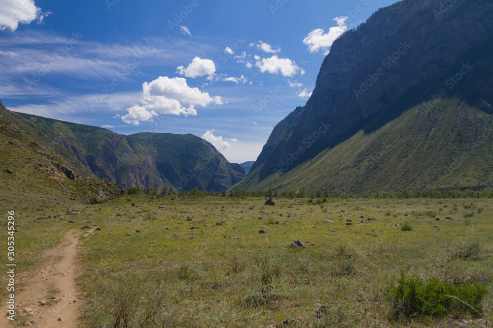 Panoramic view of a mountain valley, summer day, path for walking Panoramic view of a mountain valley, summer day, path for walking