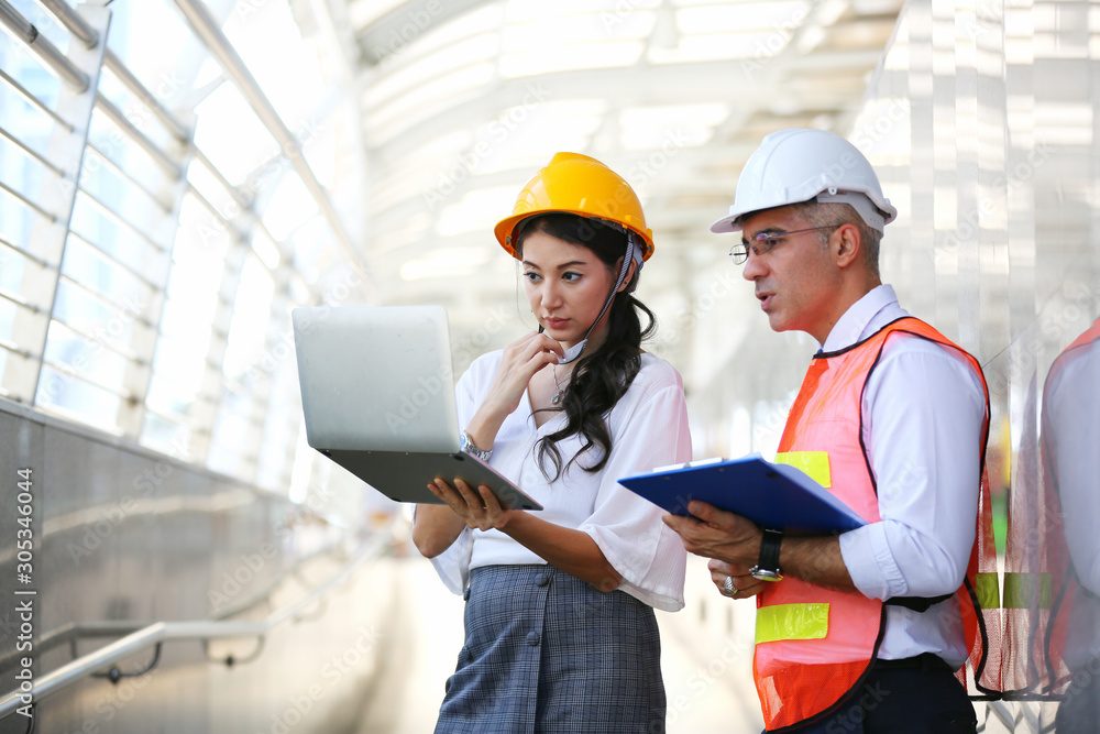 Portrait of multiethnic architect with blueprints and business industrial man engineer at construction building Portrait of multiethnic architect with blueprints and business industrial man engineer at construction building