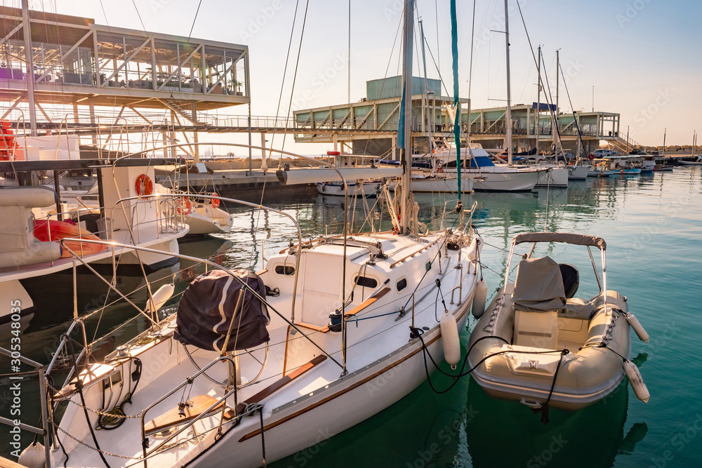 Fototapeta premium Cyprus. Limassol. Coast of the Mediterranean sea. Boats and yachts at the pier. Pavilions for relaxation with sea views. Promenade Of Molos. Port pier. Cruise port.