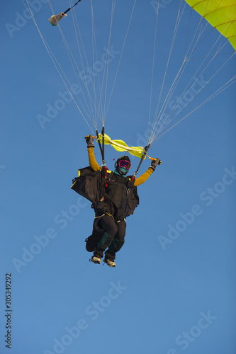 Skydiver under the canopy of the parachute against a blue sky, close-up. Parachute jumps. Skydiving.