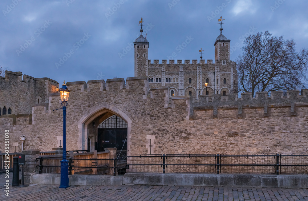 The wooden gate and exterior stone wall of the Tower of London in London England