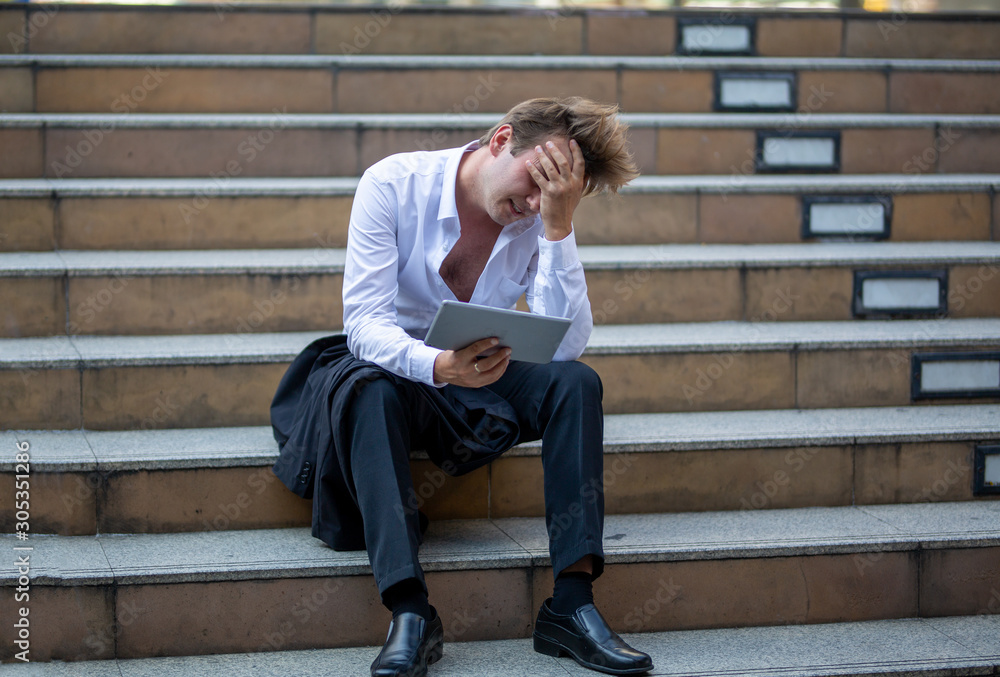 unemployed businessman stress sitting on stair, concept of business failure and unemployment problem. unemployed businessman stress sitting on stair, concept of business failure and unemployment problem.