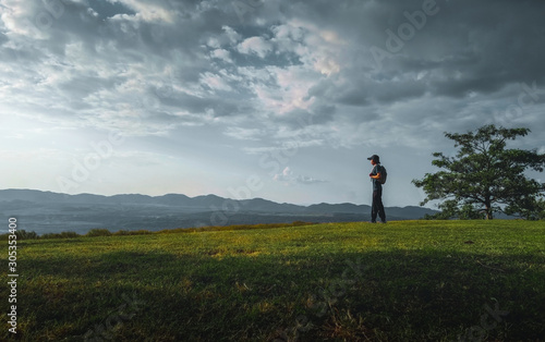 Young man traveler backpacker looking view beautiful nature landscape and cloudy sky background © Tanawat Thipmontha