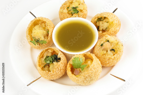 Tadeonal subcontinental street snack food chickpeas potato pani puri fuska with tamarind sauce photo