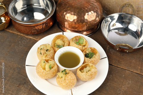 Tadeonal subcontinental street snack food chickpeas potato pani puri fuska with tamarind sauce photo