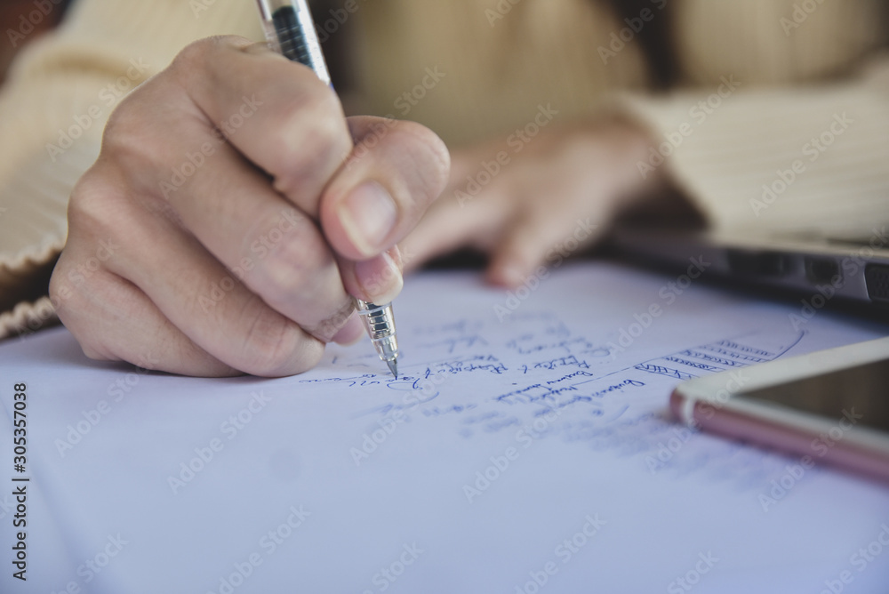 Businesswoman holding pen writing on paper document working,Close up hand write paperwork Businesswoman holding pen writing on paper document working,Close up hand write paperwork