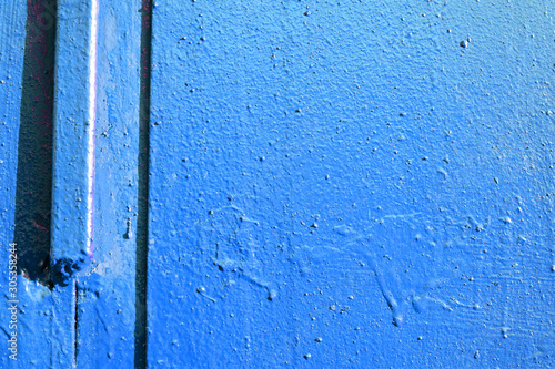 Old door blue color close-up lit by the bright sun. Abstract background © Talulla