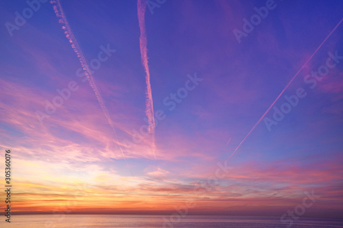 Bewitching magical gradient sky with plane traces after sunset © Goffkein