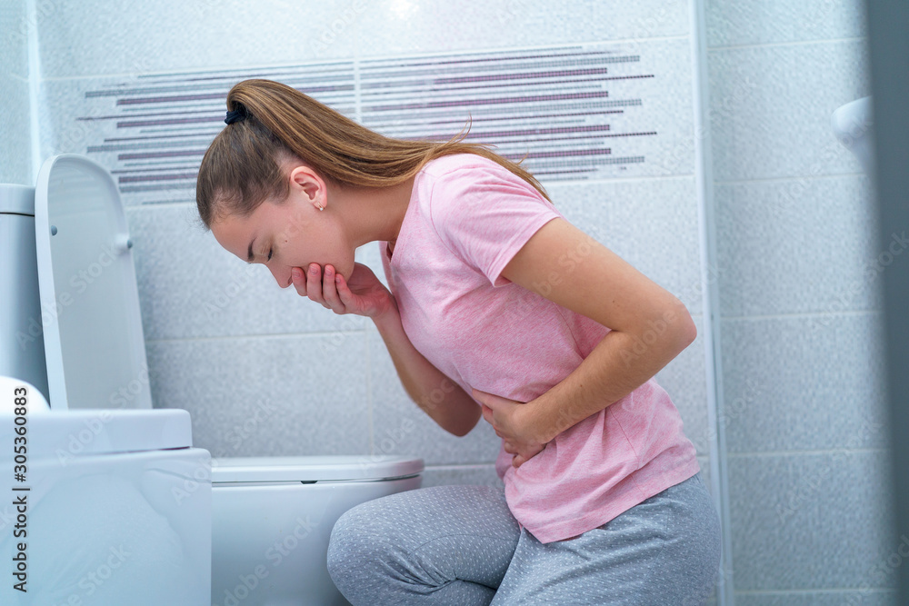 Foto de Young woman suffers from nausea and vomiting due to digestive