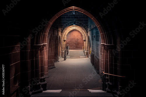 Scary pointy arcade  made of stone bricks leading to a dead end corridor dimly lit. Concept mystery and danger.