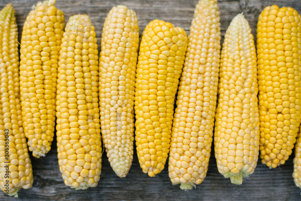 Yellow fresh organic corn, peeled ears on a wooden Board close-up Yellow fresh organic corn, peeled ears on a wooden Board close-up