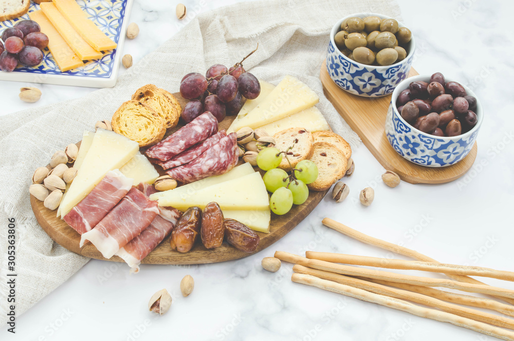 Cheese board brunch with pistachios, olives and grapes Cheese board brunch with pistachios, olives and grapes