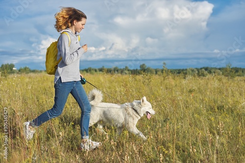 Dynamic outdoor portrait of running girl with dog © Valerii Honcharuk