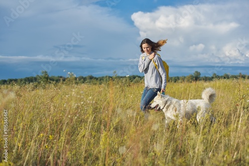 Dynamic outdoor portrait of running girl with dog