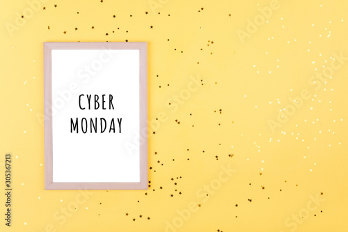 the words CYBER MONDAY in a white frame on a yellow background with gold sequins