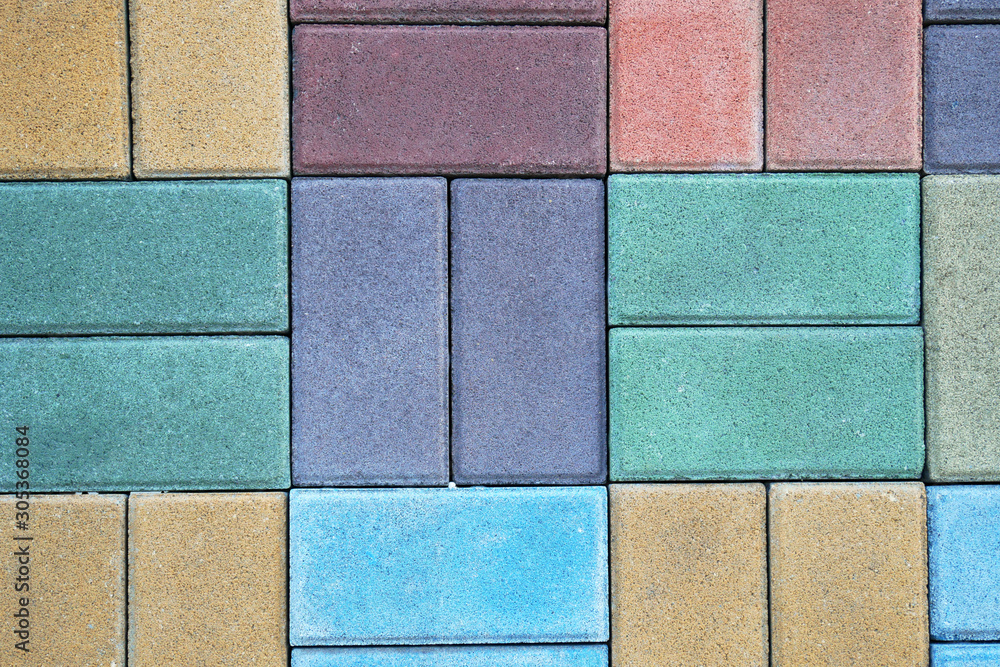 colored paving slabs by mosaic, closeup. Road paving construction. Tessellated sidewalk tile