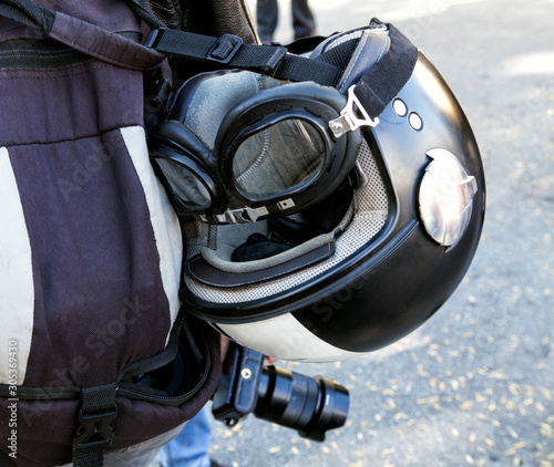 Biker helmet and camera. Photographer biker with a camera in his hand. The view from the back.