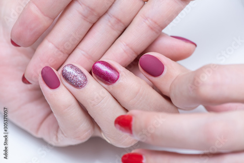 Female hands with a beautiful manicure on a white background. Gel polish in a beauty salon