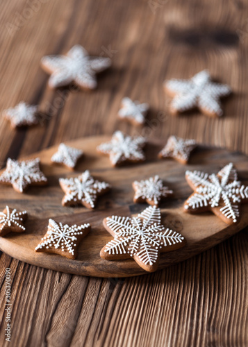 Set of homemade gingerbread on brown wooden background. Christmas cookies in stars shape.