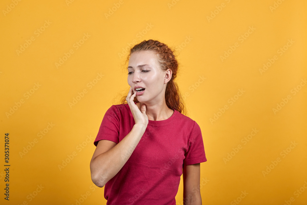 Attractive young lady in red shirt keeping hand on mouth, toothache isolated on orange background in studio. People sincere emotions, painful concept. Attractive young lady in red shirt keeping hand on mouth, toothache isolated on orange background in studio. People sincere emotions, painful concept.