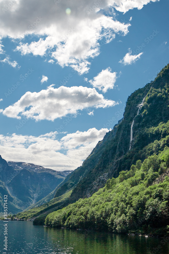 Waterfall on the fjord. Norwegian landscape with a waterfall.