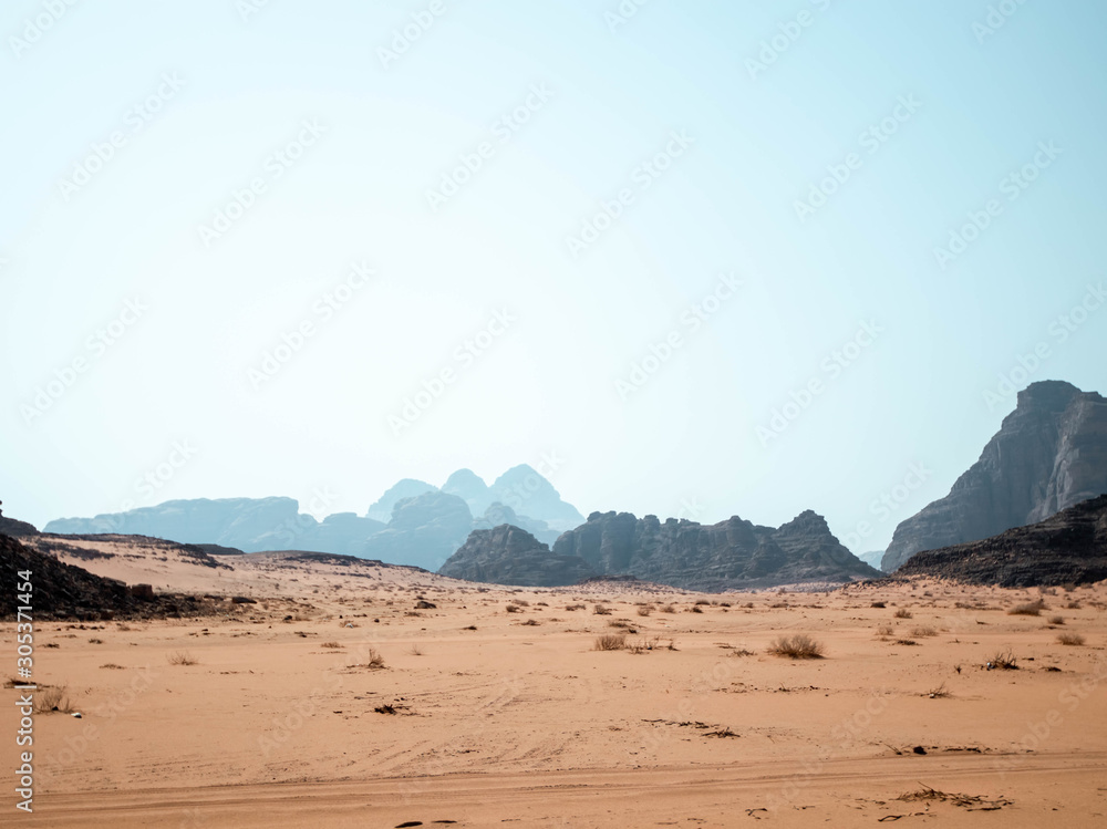 Rocky outcrops in the desert of Wadi Rum with mountains in the background