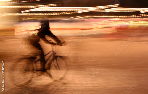 A Young Girl Riding a Bicycle at Night