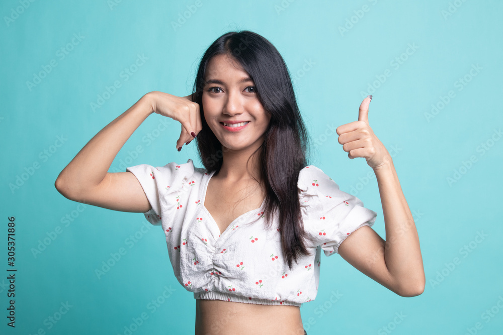 Fototapeta premium Young Asian woman thumbs up show with phone gesture.