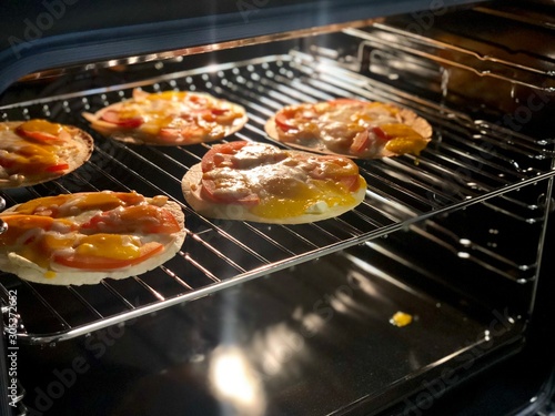 making homemade mini pizza in oven