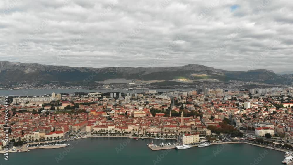 Drone slowly turning around a big Croatian city skyline on the Adriatic coast. Big high mountain landscape in the background on a cloudy day. Drone slowly turning around a big Croatian city skyline on the Adriatic coast. Big high mountain landscape in the background on a cloudy day.