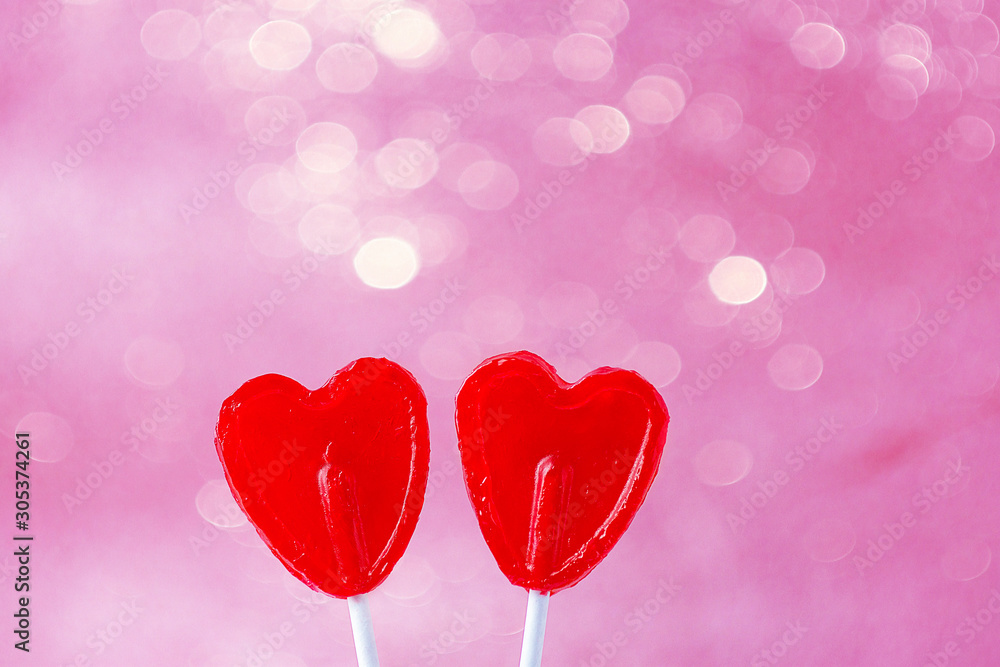Two Red Heart Shape Candy Lollipops on Sticks Pink Fuchsia Background with Sparkling Bokeh Lights. Valentine Romantic Love Greeting Card Banner Poster with Copy Space
