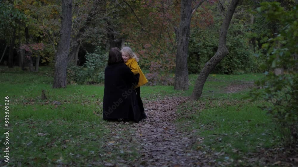 joyful meeting, a little wonderful girl cheerfully runs towards her loving mother while walking in the open-air autumn park joyful meeting, a little wonderful girl cheerfully runs towards her loving mother while walking in the open-air autumn park