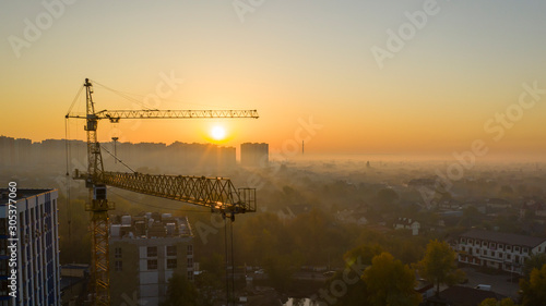 Construction cranes on the dawn background. Cityscape