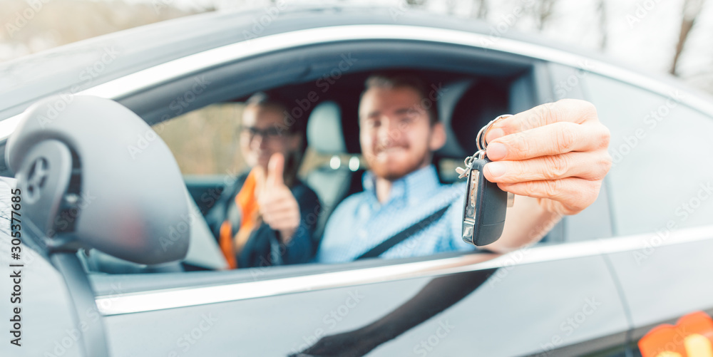 Fototapeta premium Student of driving school having passed his final test showing the car keys