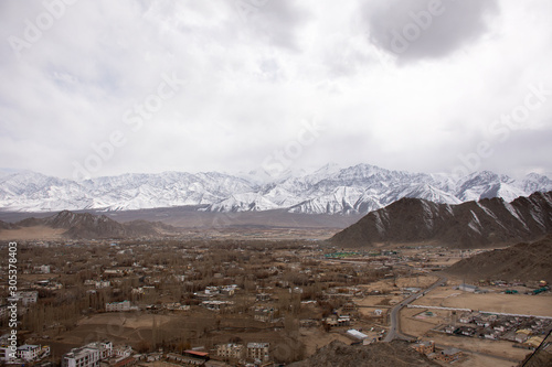 View landscape and cityscape of Leh Ladakh Village with high mountain range from viewpoint Shanti Stupa on a hilltop in Chanspa while winter season in Jammu and Kashmir, India
