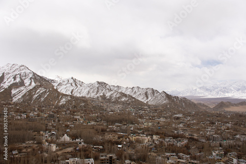 View landscape and cityscape of Leh Ladakh Village with high mountain range from viewpoint Shanti Stupa on a hilltop in Chanspa while winter season in Jammu and Kashmir, India